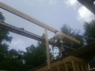Carpenter setting a ridge beam over a new addition frame — Ice Dam Removal by Roofing Brothers in Ogden