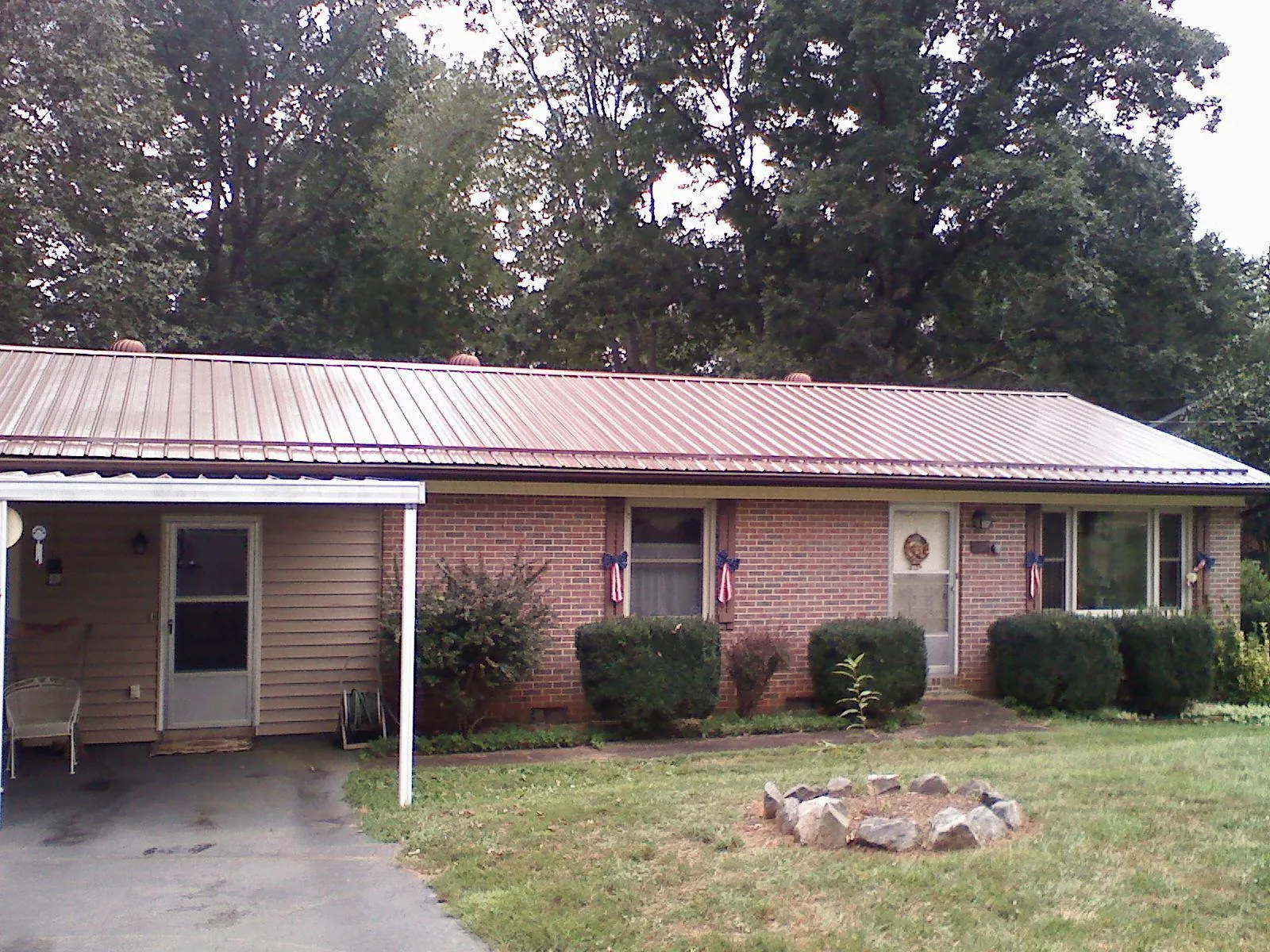 Bronze metal roof and carport on a brick ranch home — Roof Repair work by our crew in Ogden
