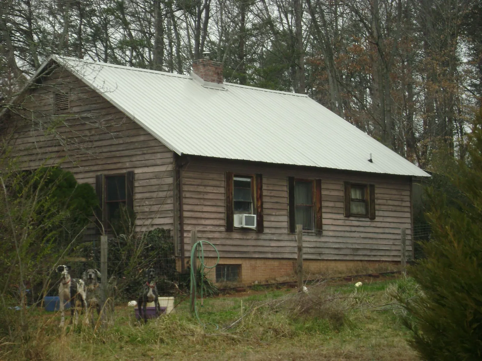 White metal roof on an old wood sided farmhouse, from a Metal Roof Installation job in Ogden